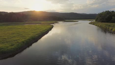 Vista-Cinematográfica-Desde-Un-Dron-Volando-Sobre-Un-Río-Al-Atardecer-En-El-Campo