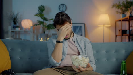 man watching movie at home with popcorn