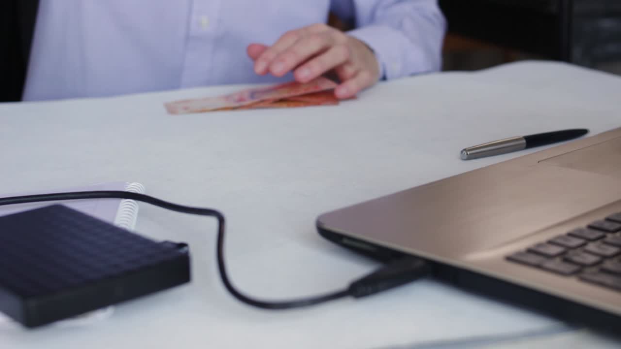 hombre de negocios en el trabajo en la mesa de la oficina con computadora portátil y billetes de pesos argentinos