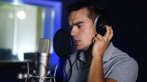 hombre cantando en un micrófono en un estudio de grabación