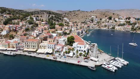 scenic summer promenade in symi, colorful city, aerial sideways establisher