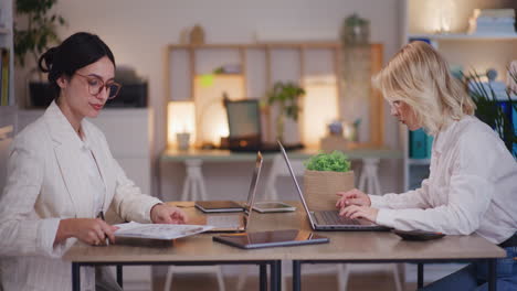 Two-Women-Work-Late-in-Corporate-Office-on-Laptops