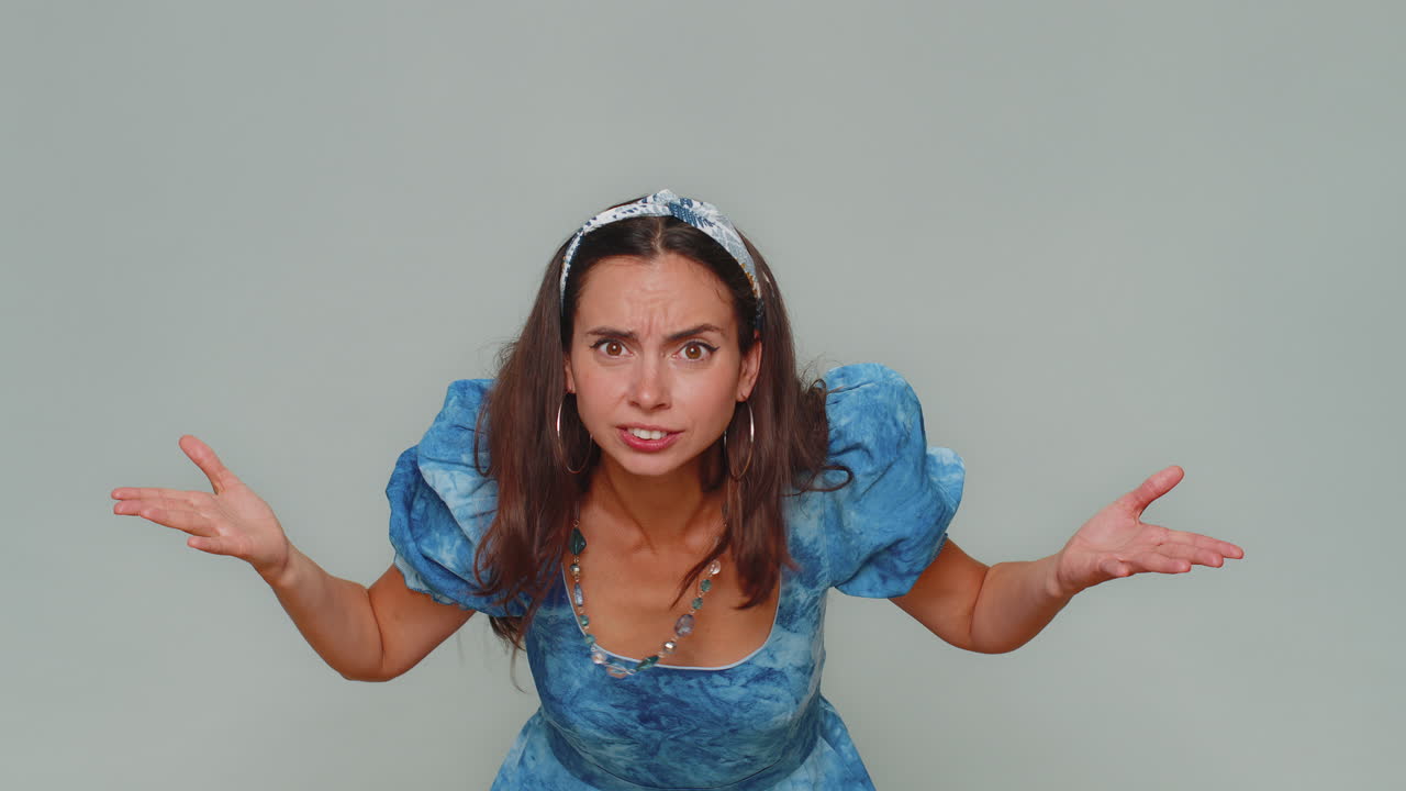 mujer joven tratando de oírte, mirando confundido y fruncido, manteniendo el brazo cerca de la oreja para una voz más alta