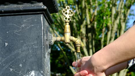 Hände-Waschen-Junger-Mann,-Der-Seine-Hand-Im-Park-Wäscht