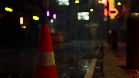 cono de tráfico en una calle húmeda de la ciudad por la noche