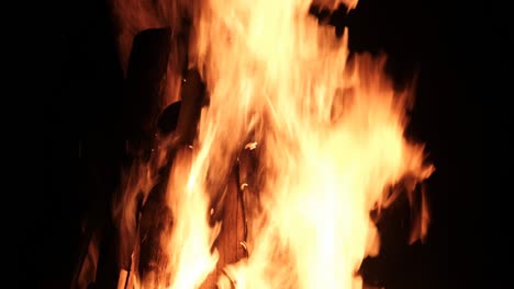una gran hoguera arde por la noche en cámara lenta sobre un fondo negro en la naturaleza