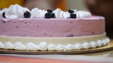 primer plano de un pastel de bayas rosas con crema batida