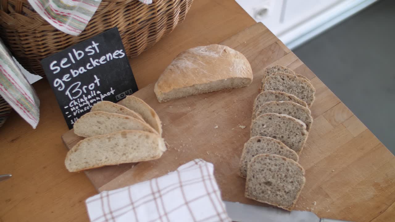 칼과 수건이 놓여 있는 나무 테이블에 놓인 신선한 통곡물 빵과 흰 빵