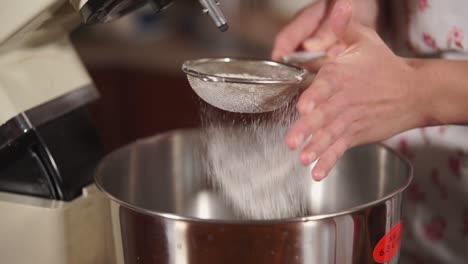 sifting flour into mixing bowl