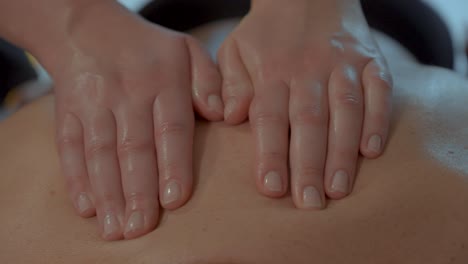 skilled oily hands glide over back of person providing soothing thalasso massage