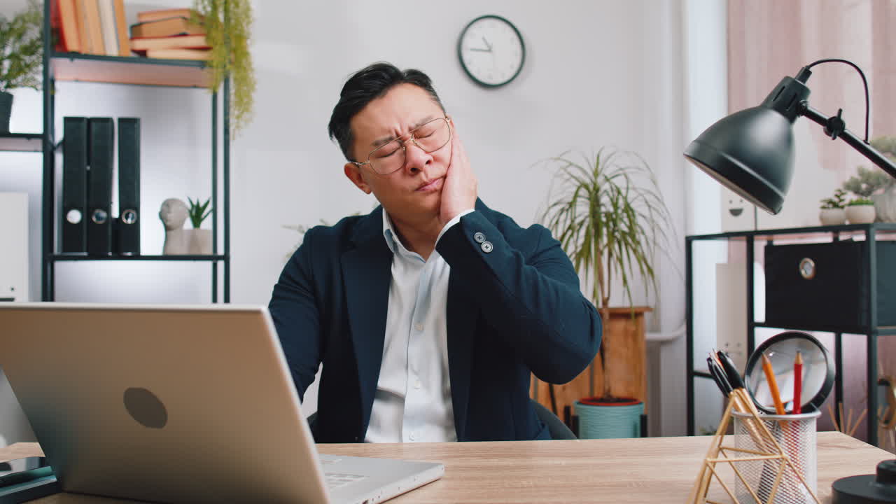 Business man touching cheek closing eyes with expression of terrible suffer from painful toothache
