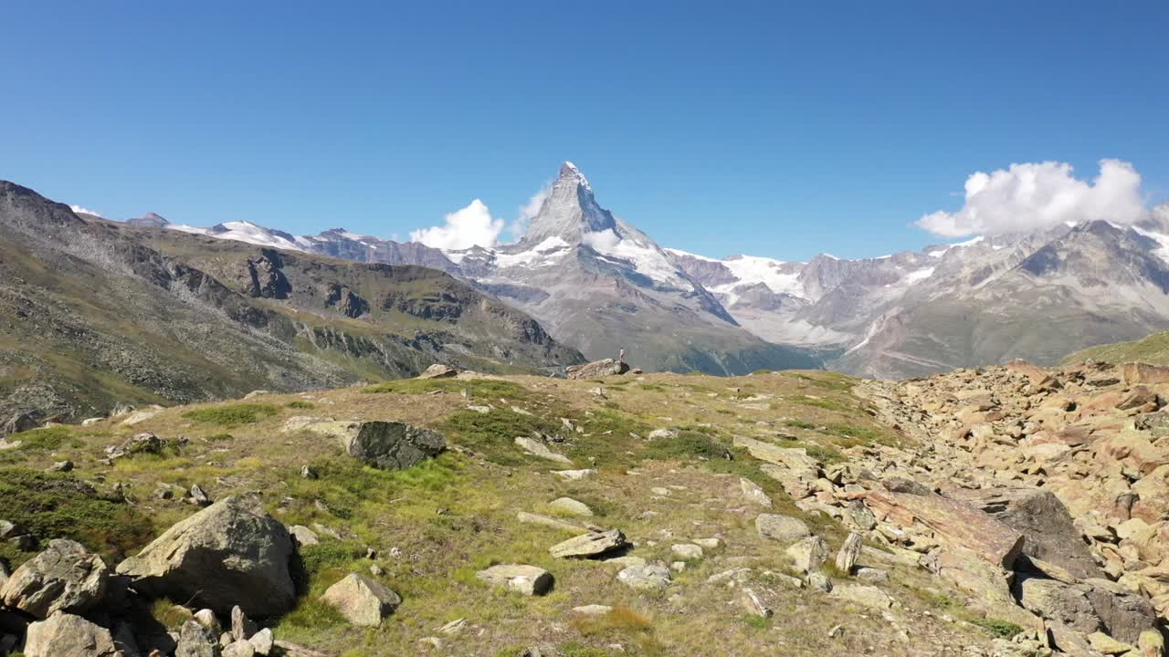 drone disparado volando sobre grandes rocas y rocas en el borde de un acantilado a un gran, exuberante y verde valle durante el verano en zermatt, suiza