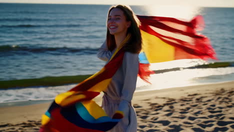 a woman on a beach holding a colorful flag