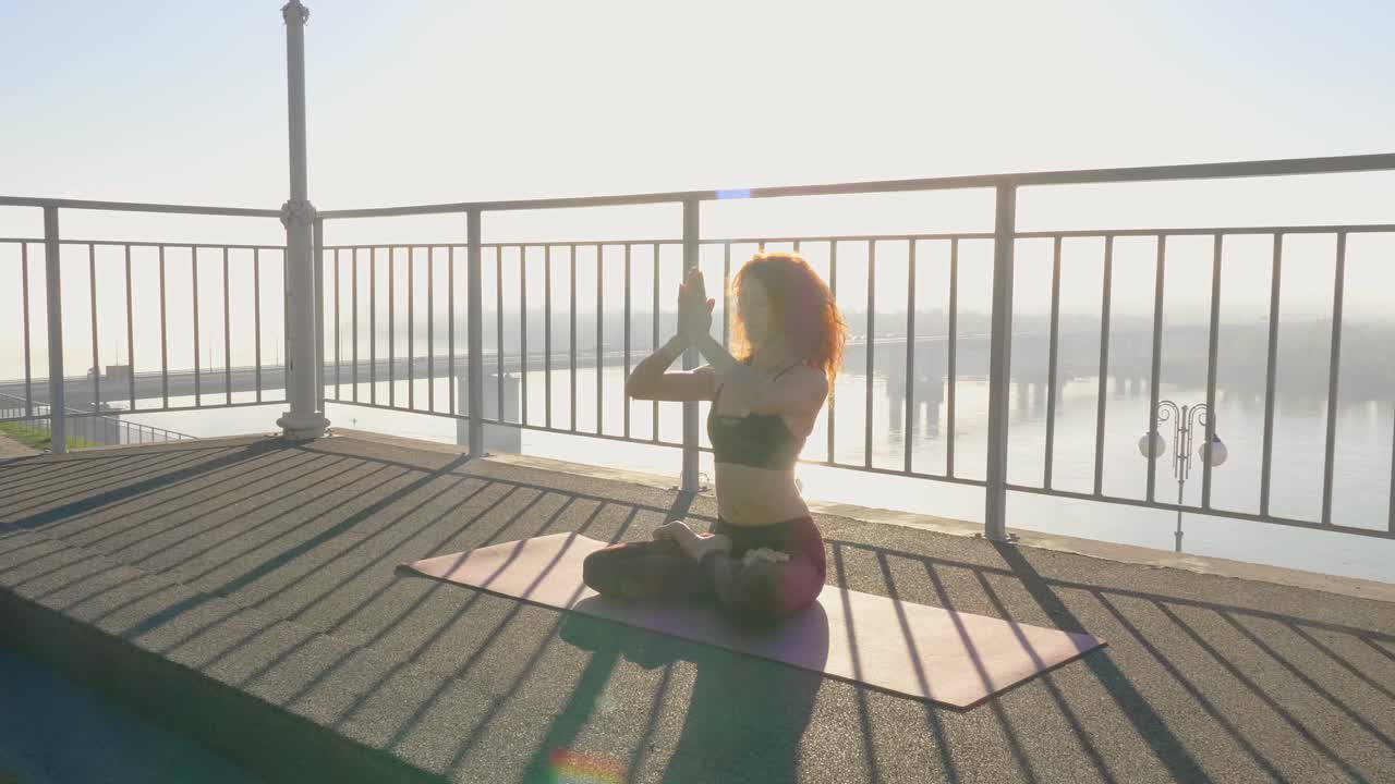 Woman Practicing Yoga on Rooftop with River View