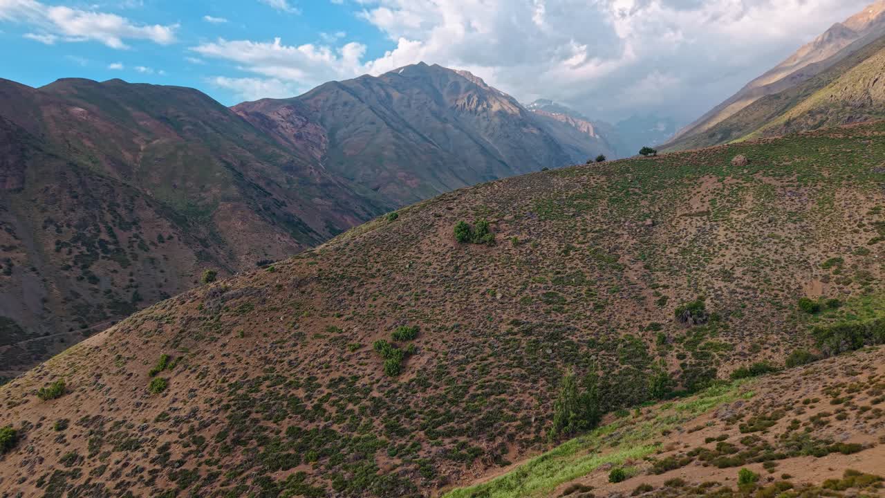 Cinematic traveling aerial view of the Andes Mountains on a sunny day, Chile