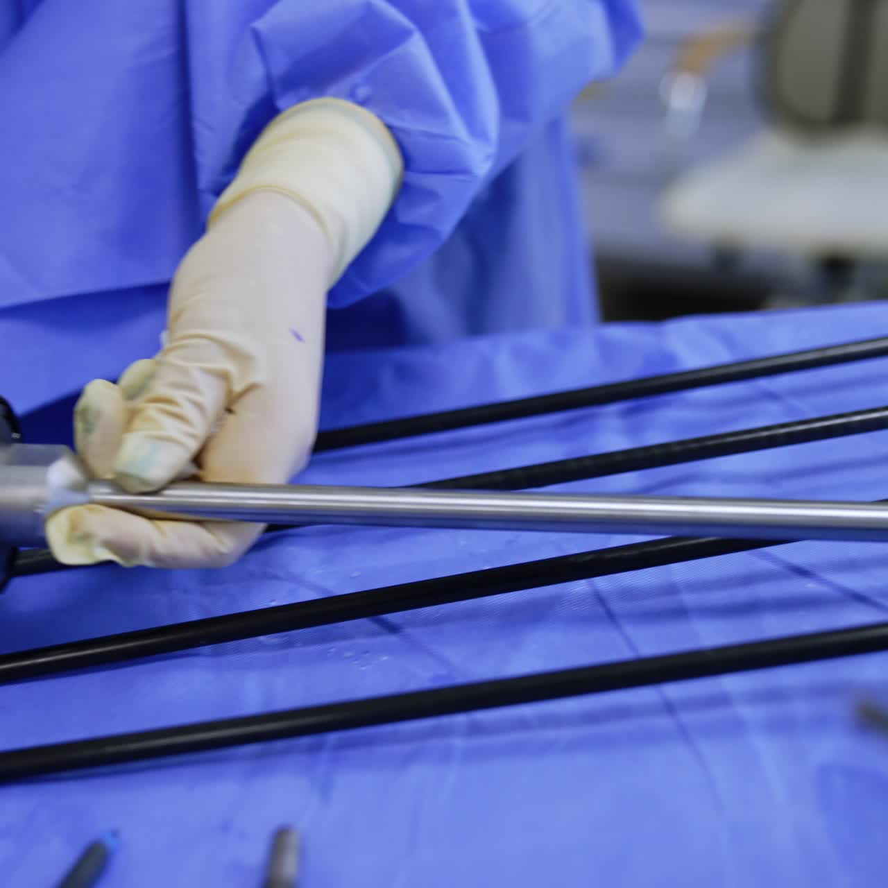 Female medic in uniform, mask and cap holding a device from a robotic surgeon system. Modern technology used in medicine and surgery