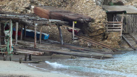 Right-pan-of-some-old-fishermen's-houses-in-Cala-Benirras,-Ibiza,-Spain