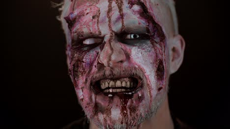 maquillaje facial de hombre zombi con heridas cicatrices y lentes de contacto blancas sangre fluye y gotea en la cara