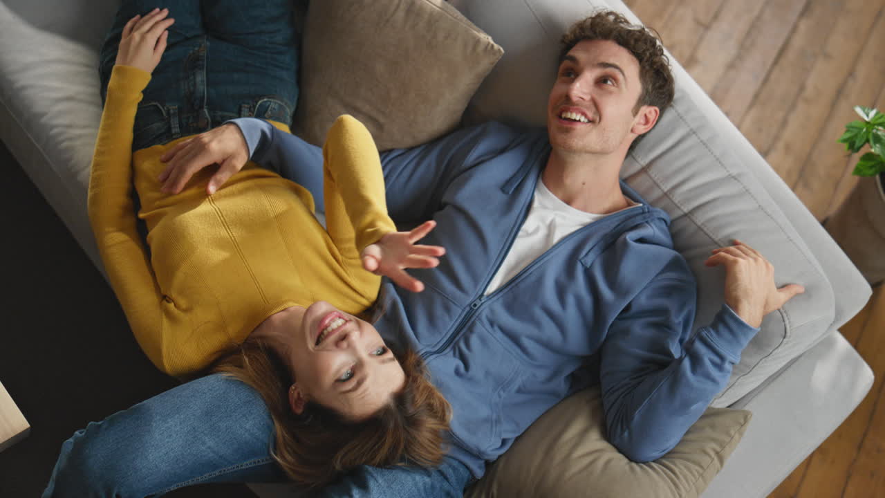 Happy pair enjoying weekend talking at couch closeup. Lovers imagining future