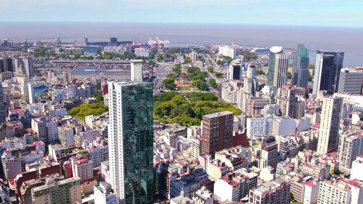 Vista aérea em aproximação da Praça General San Martin e da Torre Monumental no bairro do Retiro, com o porto ao fundo.