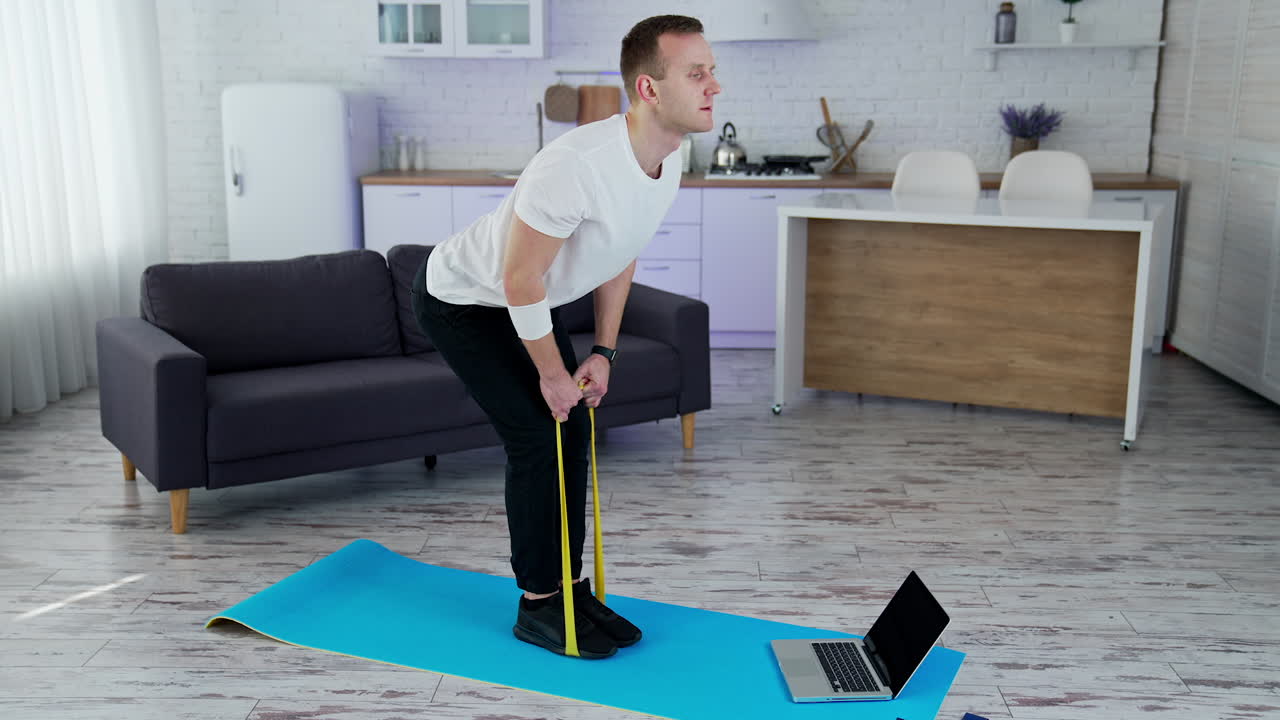 Strong healthy man training indoor on quarantine. Athletic handsome man working out in home.