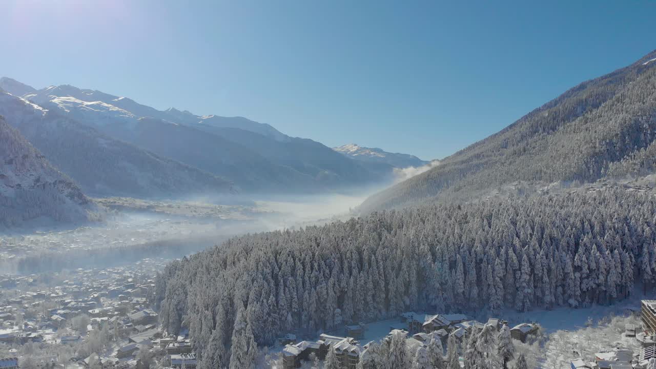 Aerial Dolly Zoom-In shot of Old-Manali town being soaked in white Snowflakes after a heavy snowfall during the winters, shot with a drone in 4k