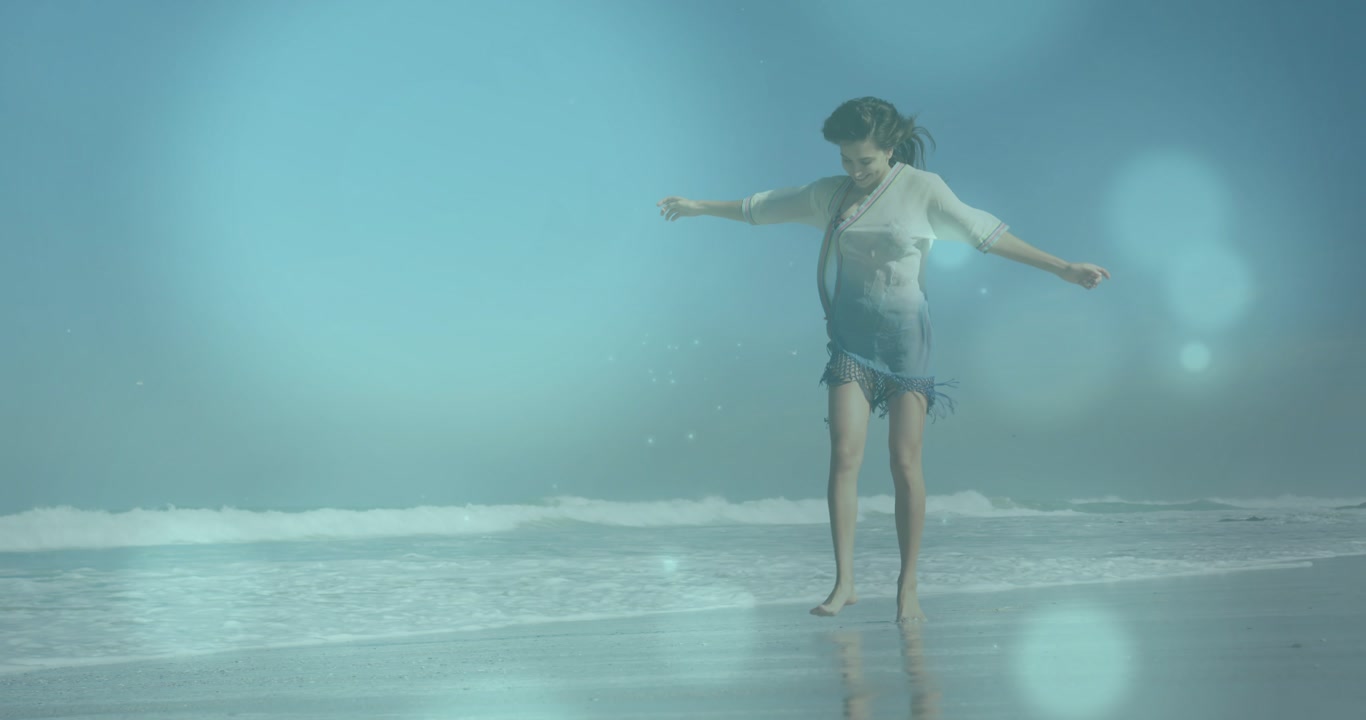Woman walking shore stepping toward lens sparking animated bokeh reflecting on wet sand for travel