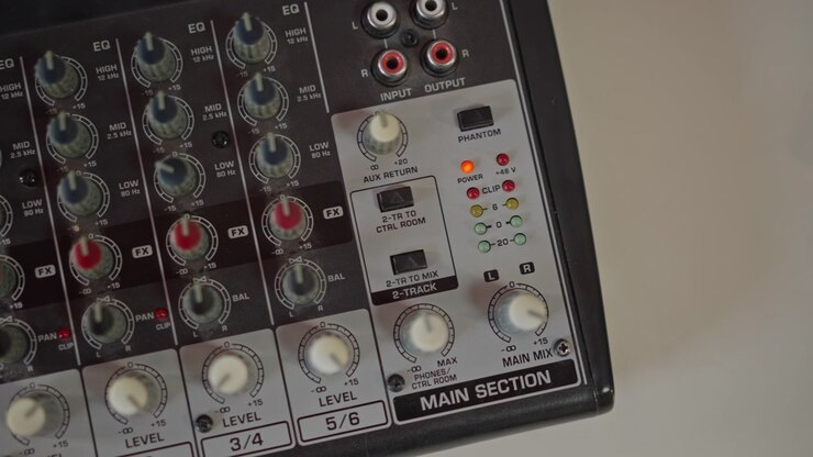 Broadcast mixing console featuring LED indicators and labeled dials. Professional audio mixing interface with lighting signals and clearly marked controls for live streaming optimization