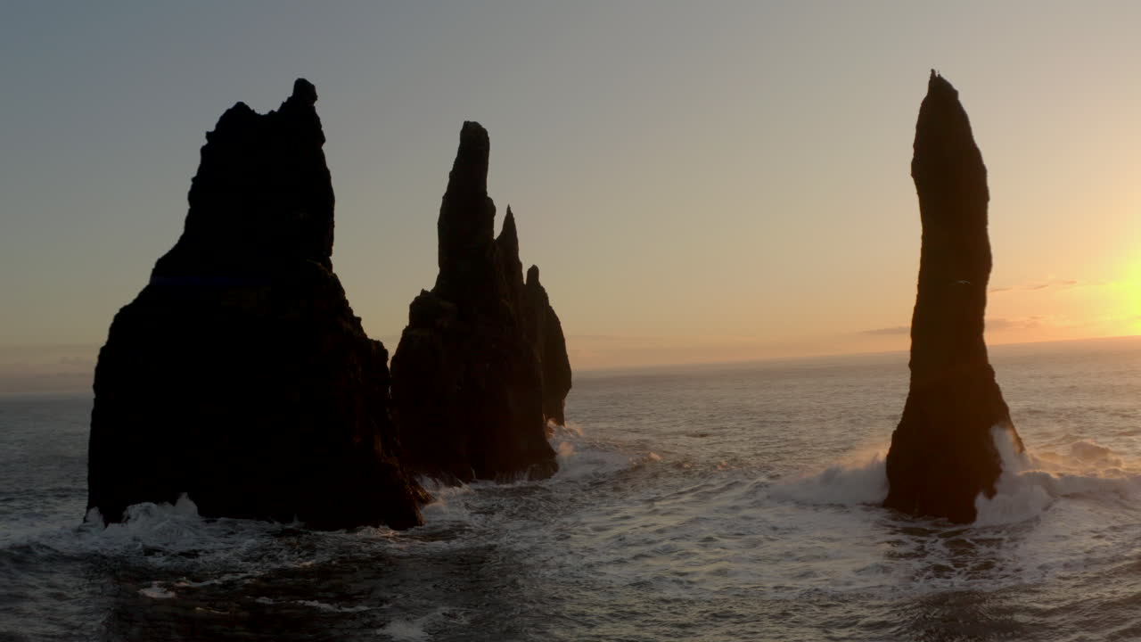 toma aérea en círculos alrededor de reynisdrangar pilas de mar islandia