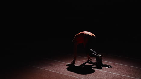 runner in starting position at night