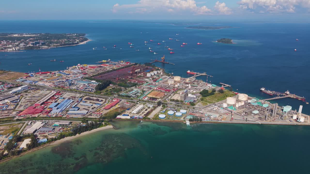 Aerial view of Rancha-Rancha Industrial Estate, Labuan, Malaysia, showing oil and gas terminals, storage tanks, and vessels along the tropical coast. Perfect for industry or energy footage