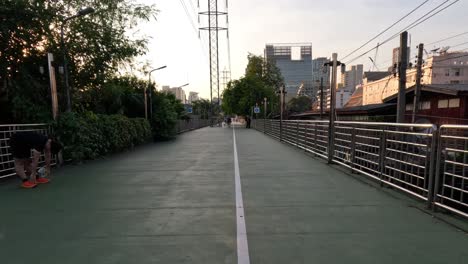 people enjoying a walk in a city park at dusk.