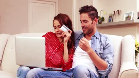 pareja feliz comprando en línea en una computadora portátil