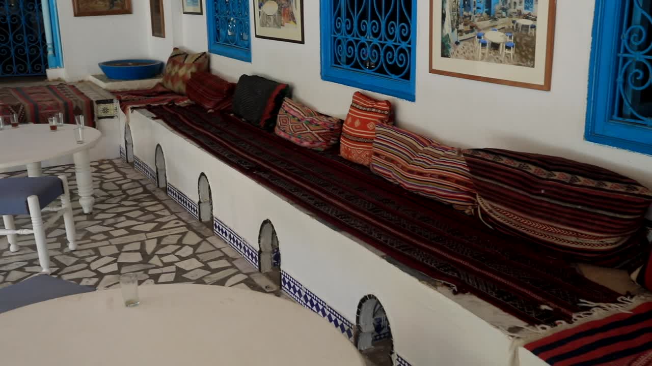 Traditionelle tunesische Lounge mit farbenfrohen Textilien und aufwendigen Fliesenarbeiten, Sidi Bou Said.