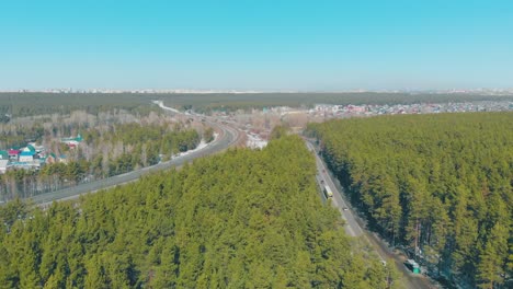 Carreteras-Grises-Con-Coches-En-Marcha-Rodeados-De-Pinos-Verdes.