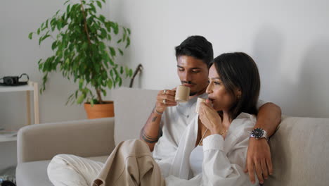 happy lovers enjoying tea at home closeup. love couple relaxing with coffee cups