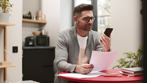 man with documents talking on phone
