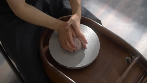 person shaping clay on a pottery wheel