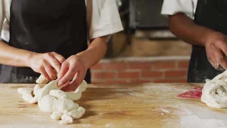 animation of hands of diverse female and male bakers making rolls at bakery