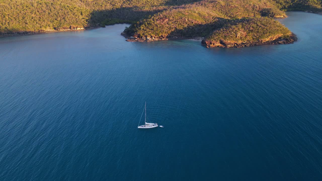 velero con bote flotante en aguas tranquilas de la entrada de nara - isla gancho en whitsundays, australia