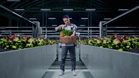 cuerpo lleno de cansado agricultor masculino asiático con canasta de verduras mientras estaba de pie en la granja inteligente