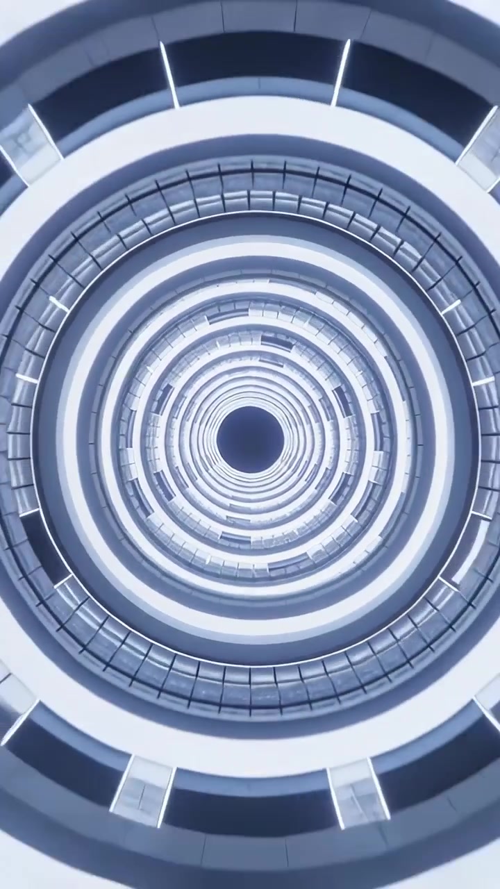 Video verticale: Telecamera che sale mostrando un atrio in asse, rivelando un vuoto centrale e anelli LED sovrapposti.