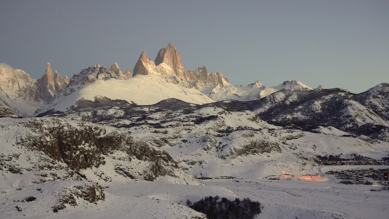 Vista invernale mozzafiato di El Chalten all'alba, circondato da un paesaggio innevato.