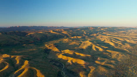 Simpson-Desert-Aerial-Drone-On-Clear-Day-With-Blue-Sky-And-Sunlight-Shadow-On-Mountains,-4K-Australia