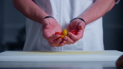 A-chef-placing-tomatoes-on-a-cutting-board-in-the-kitchen