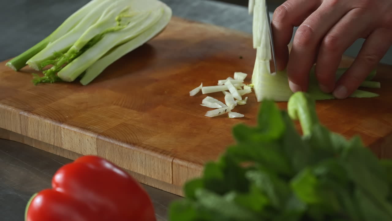 Chef chopping fennel fast on a wooden chopping board,vegetables