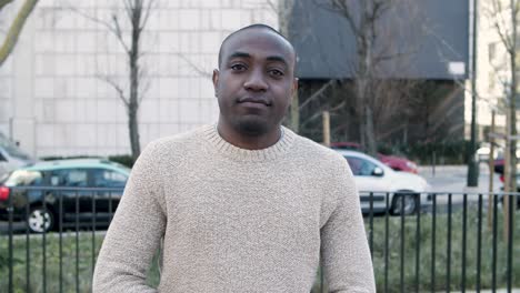 front view of cheerful guy standing and looking at camera