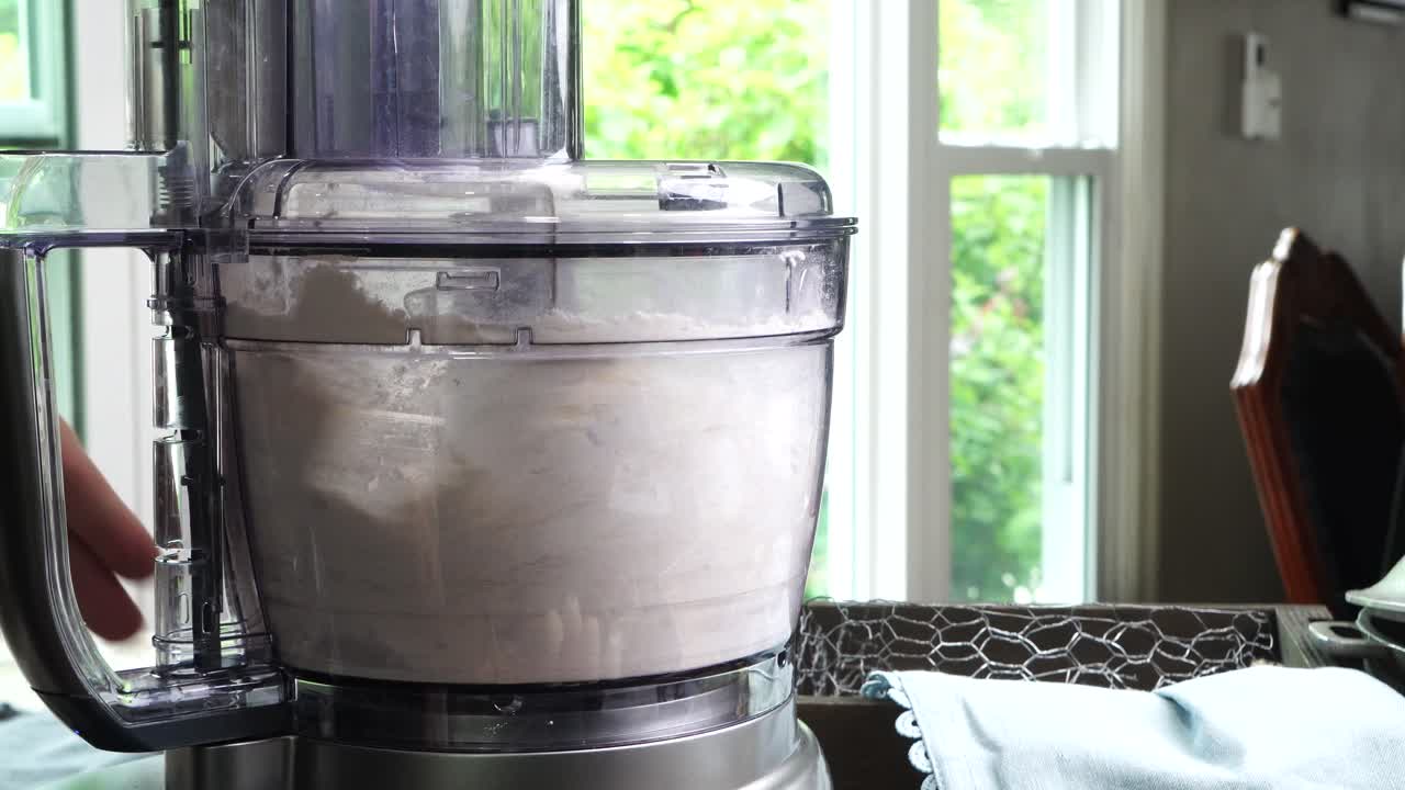 Using a food process or blender to make a dessert crust. Close up of mixing baking ingredients to make a dessert with a pie crust. Making brownies with a food processor for dessert.
