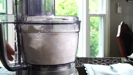 using a food process or blender to make a dessert crust. close up of mixing baking ingredients to make a dessert with a pie crust. making brownies with a food processor for dessert.