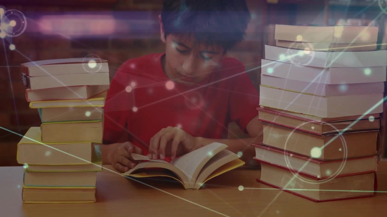 Boy opening book on table and activating floating digital graphics while reading enhancing learning